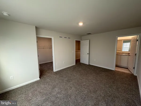 an empty room with closet and windows