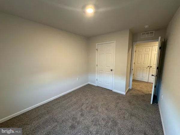 an empty room with an entrance and mirror