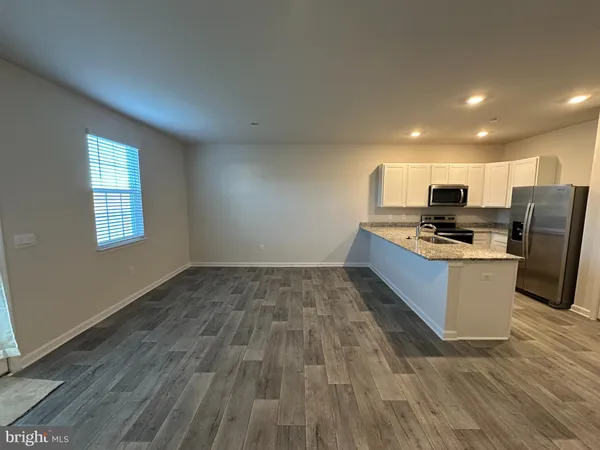 a kitchen with wooden floors and stainless steel appliances