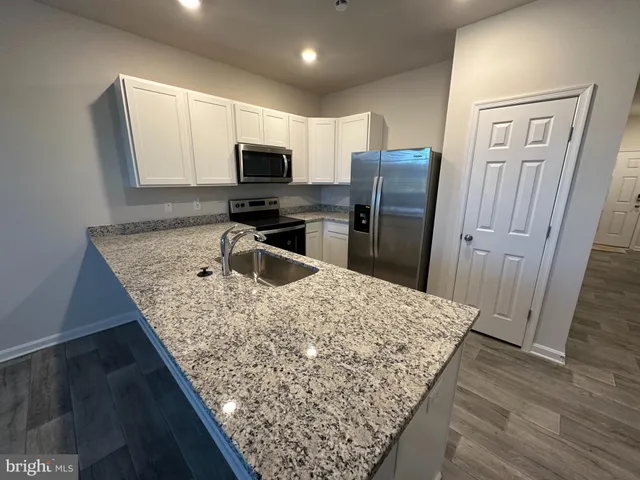 a kitchen with stainless steel appliances granite countertop a sink refrigerator and microwave