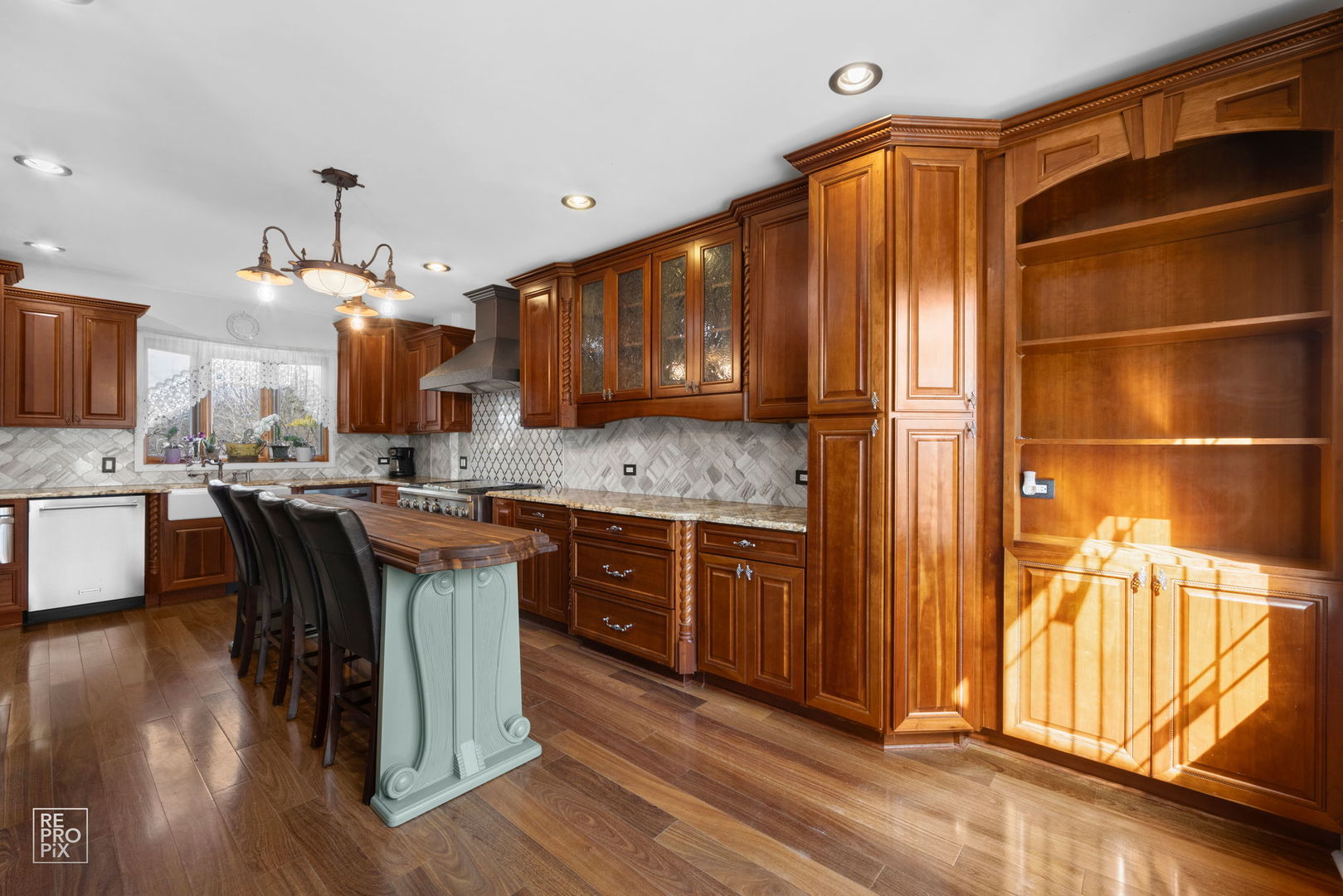 726 South Naperville Road Wheaton, IL 60187 - Photo 4 of 28 a kitchen with kitchen island granite countertop wooden floors wooden cabinets a center island and stainless steel appliances