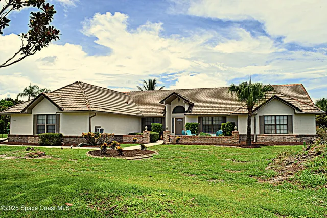 a front view of a house with a garden and sitting area