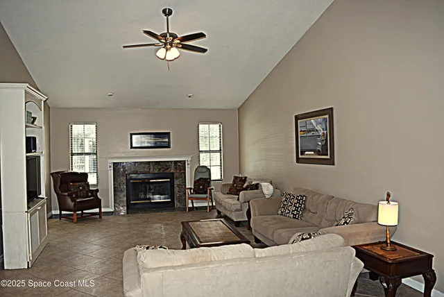 a living room with furniture a fireplace and a flat screen tv