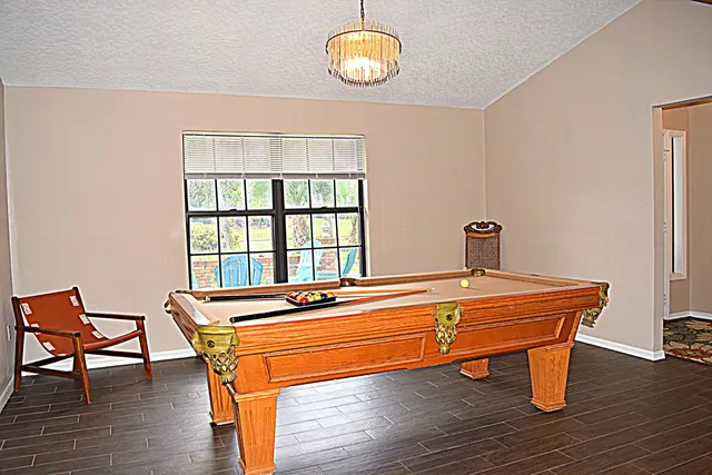 a room with wooden floor table and chairs