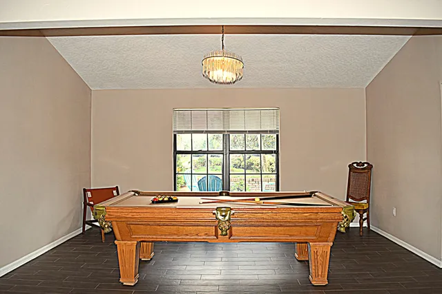 a room with pool table and wooden floor