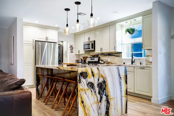 a kitchen with refrigerator cabinets and wooden floor