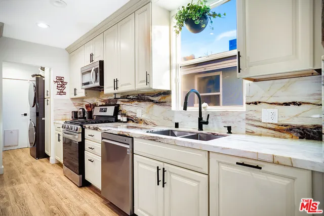a kitchen with stainless steel appliances granite countertop a sink stove and cabinets