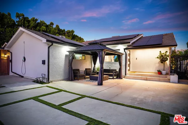 a view of a patio with table and chairs under an umbrella