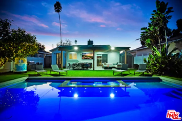 a view of a house with backyard water fountain and sitting area