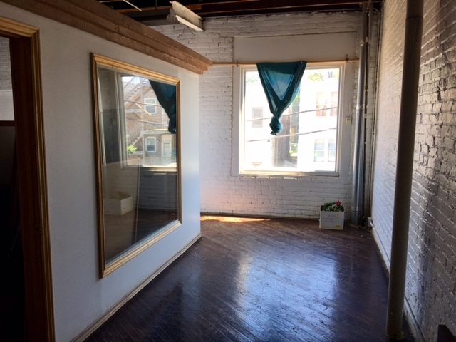 2425 West Division Street Chicago, IL 60622 - Photo 4 of 10 an empty room with wooden floor a mirror and windows