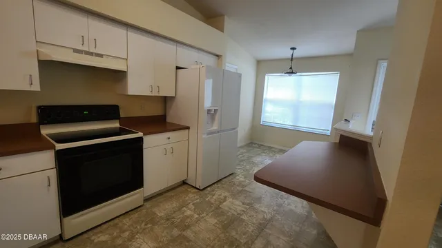 a room with a sink a stove and cabinets