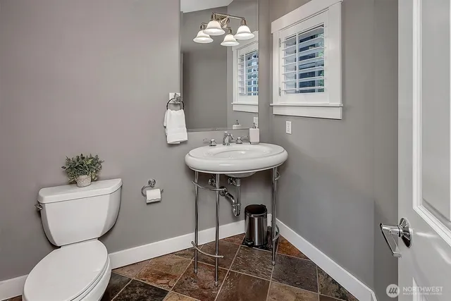 a bathroom with a toilet a sink and a mirror