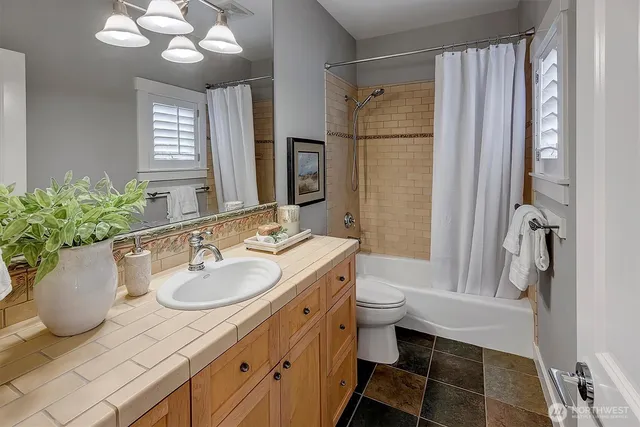 a bathroom with a granite countertop sink toilet and shower