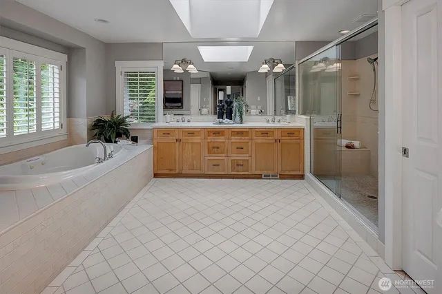 a bathroom with a granite countertop sink a mirror a bathtub and shower