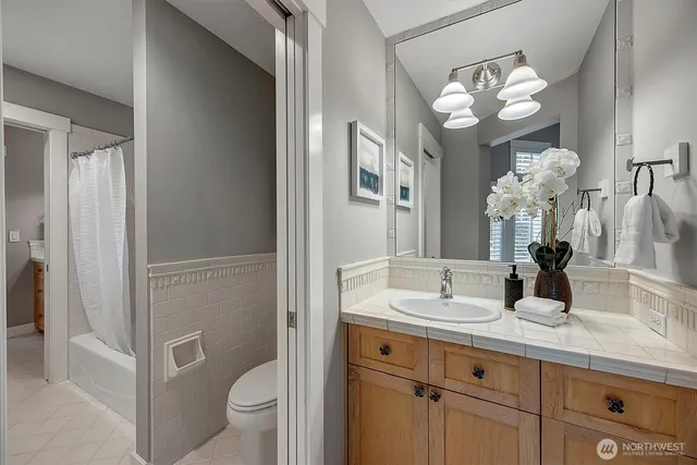 a bathroom with a granite countertop sink a toilet and a mirror
