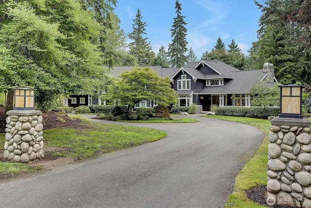 a front view of a house with a garden and trees