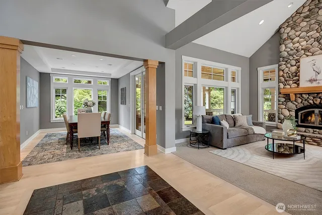 a living room with furniture a fireplace and large windows