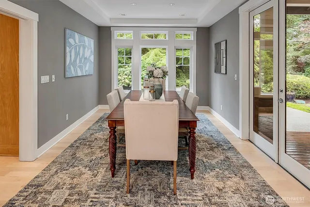 a dining room with wooden floor and a rug