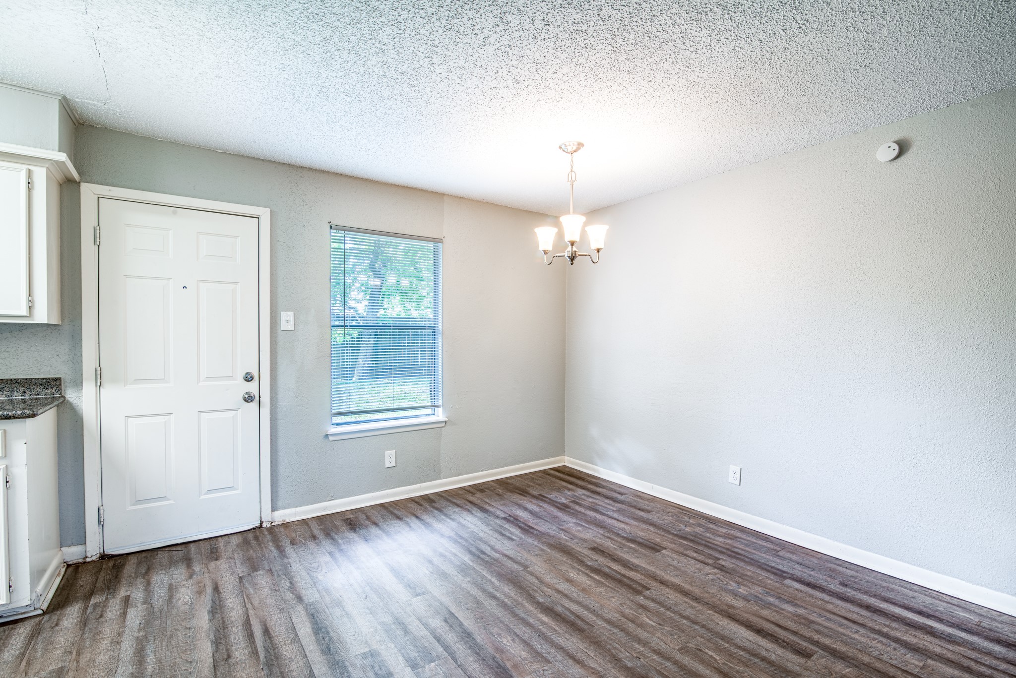828 Noreda Street Angleton, TX 77515 - Photo 12 of 28 an empty room with wooden floor chandelier and windows