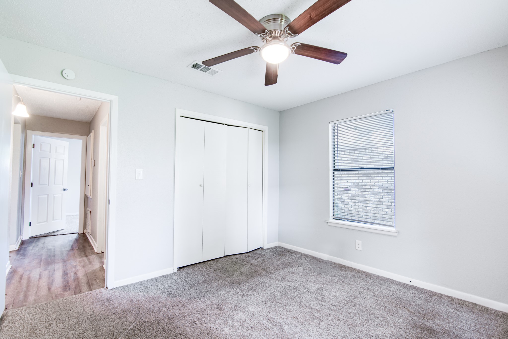 828 Noreda Street Angleton, TX 77515 - Photo 20 of 28 an empty room with wooden floor ceiling fan and windows