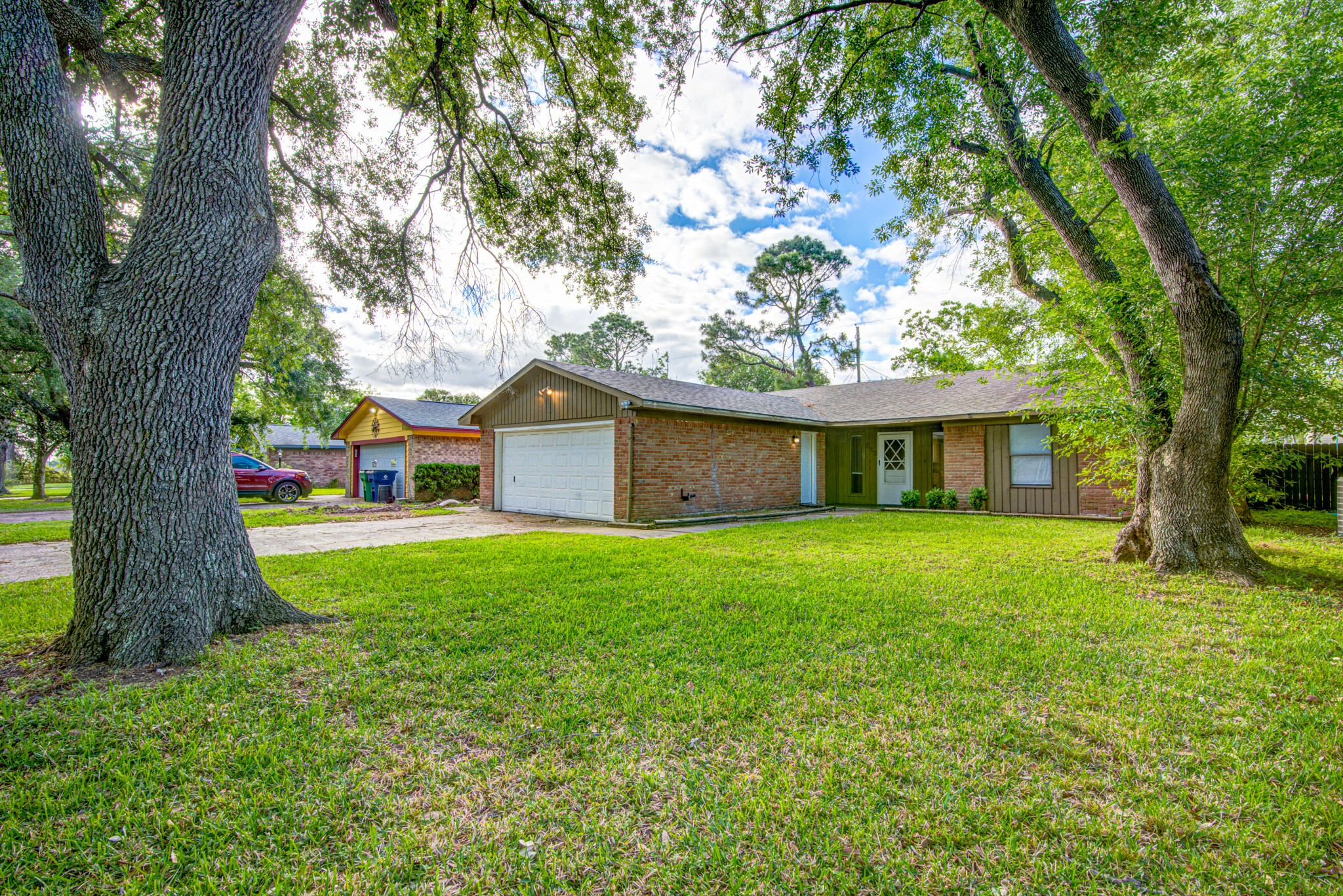 828 Noreda Street Angleton, TX 77515 - Photo 6 of 28 a front view of a house with a garden and trees