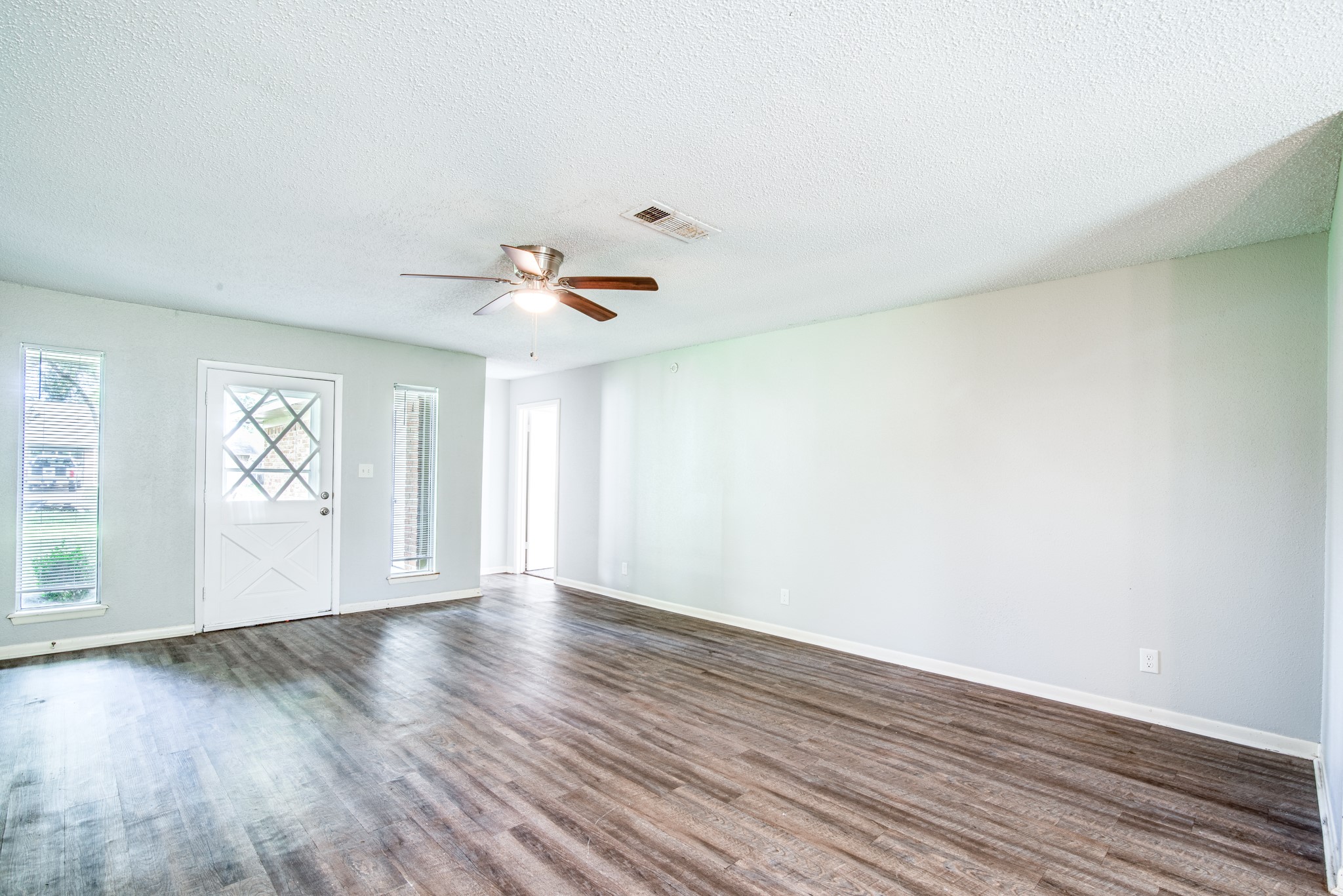 828 Noreda Street Angleton, TX 77515 - Photo 9 of 28 a view of an empty room with wooden floor and a window