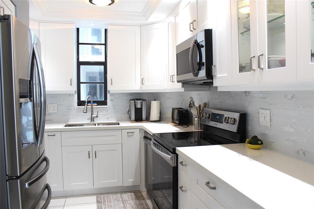 1000 South Ocean Boulevard, Unit 11K Pompano Beach, FL 33062 - Photo 11 of 25 a kitchen with a sink and cabinets