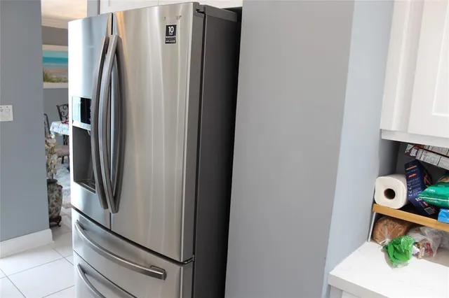 a metallic refrigerator freezer sitting in a kitchen