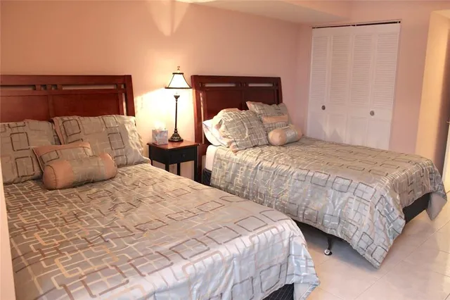 a bedroom with two beds and a lamp on dresser