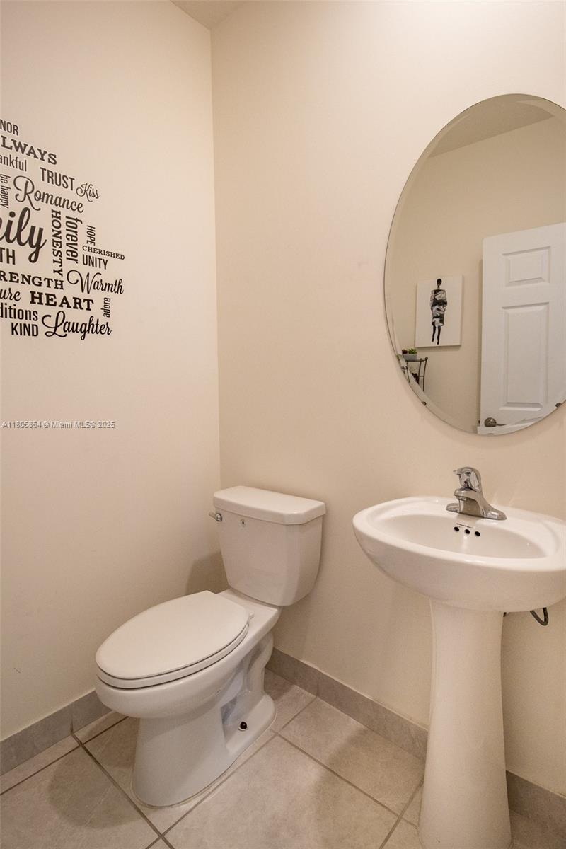 10966 West 33rd Way Hialeah, FL 33018 - Photo 14 of 43 a bathroom with a toilet a sink and mirror