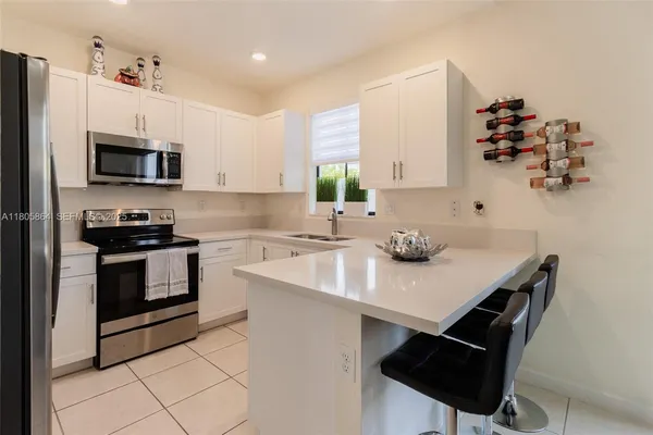 a kitchen with stainless steel appliances a sink a stove a microwave and cabinets