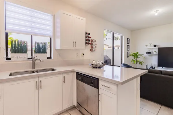 a kitchen with appliances a sink and a window