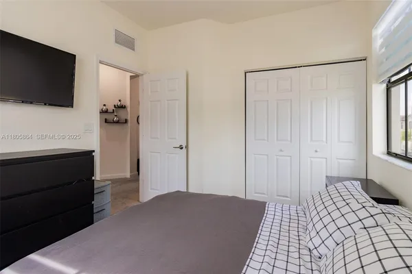 a bedroom with a bed and a flat screen tv