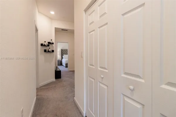 a view of a hallway with white walls and stairs