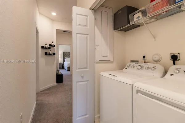 a utility room with cabinets washer and dryer