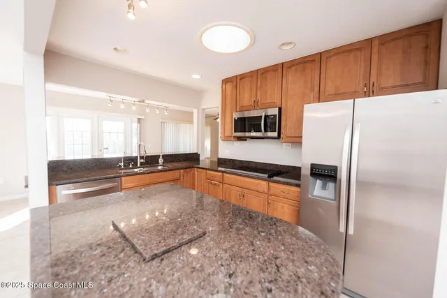 a kitchen with stainless steel appliances granite countertop a refrigerator and a stove