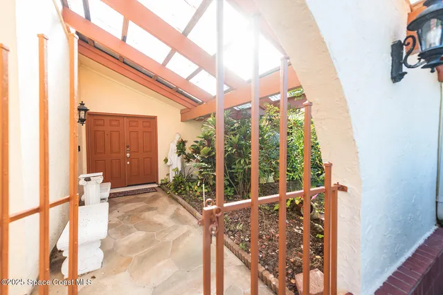a view of a tall building with a bench and potted plants