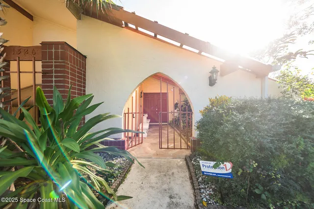 a view of an empty room with window and chandelier