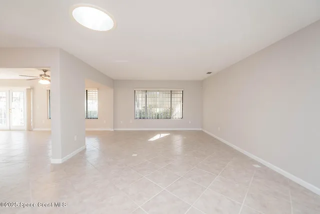 an empty room with chandelier and windows