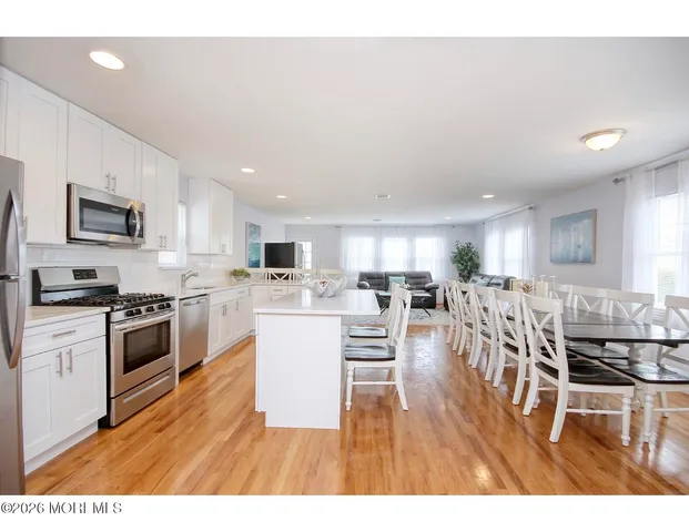 a open kitchen with white cabinets and stainless steel appliances