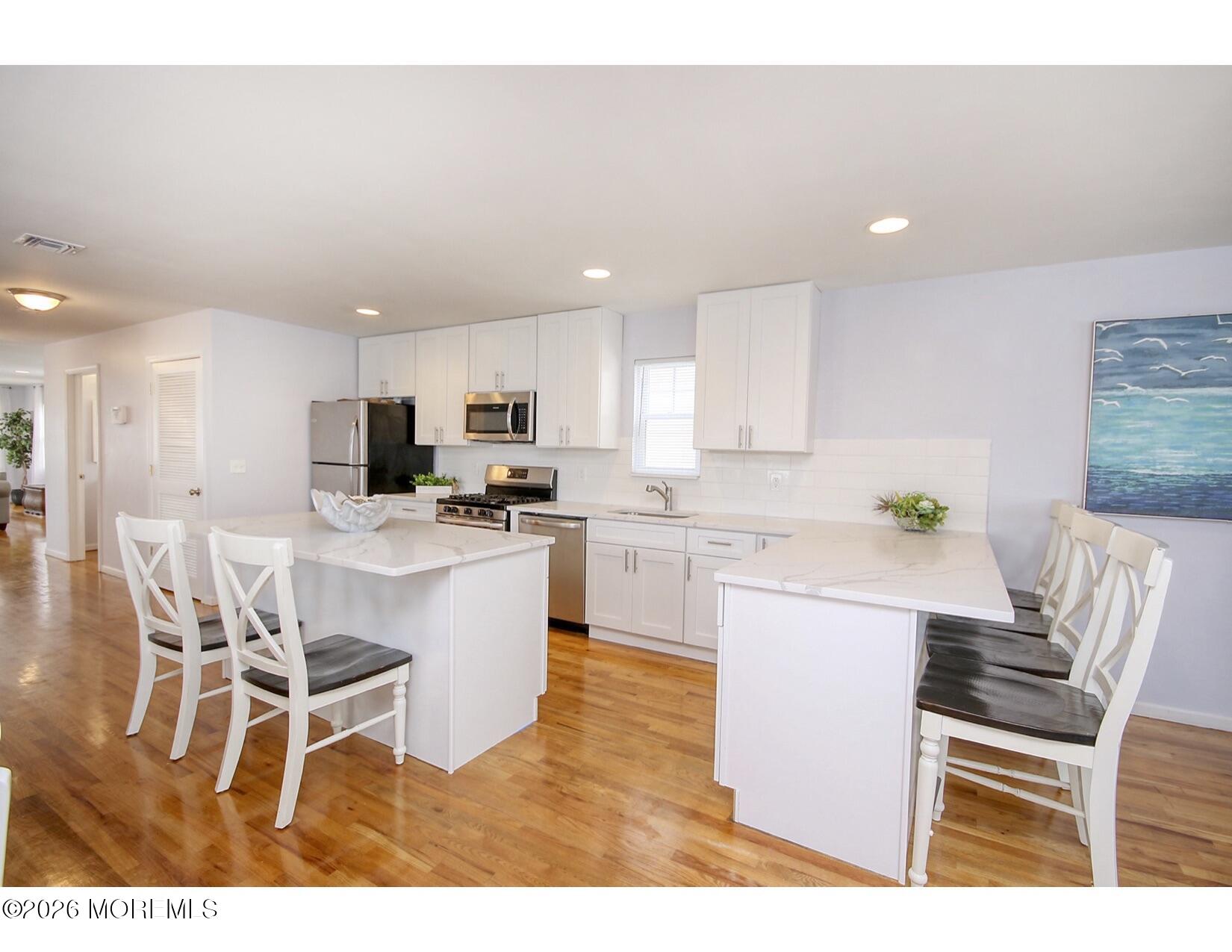 201 Arnold Avenue Point Pleasant Beach, NJ 08742 - Photo 13 of 33 a kitchen with a table chairs refrigerator and window