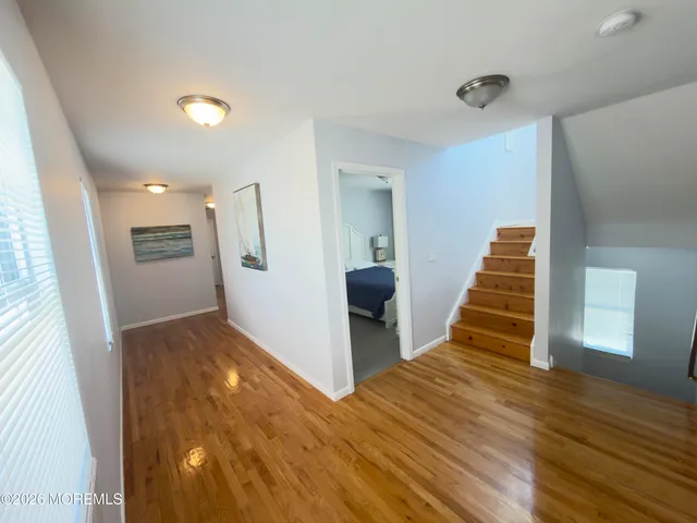 a view of a livingroom with wooden floor and stairs