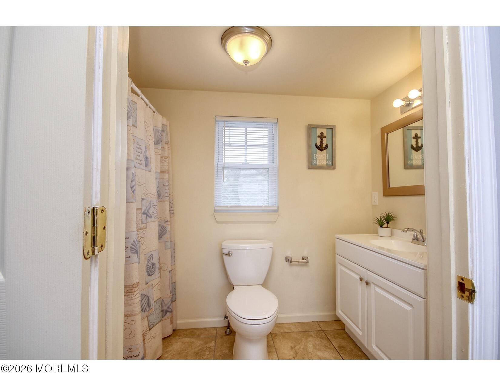 201 Arnold Avenue Point Pleasant Beach, NJ 08742 - Photo 30 of 33 a bathroom with a toilet a sink a mirror a window and vanity