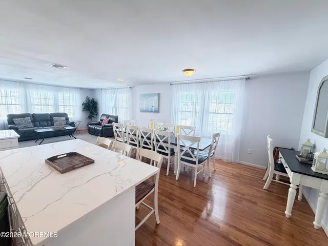 a kitchen with a dining table chairs and white cabinets