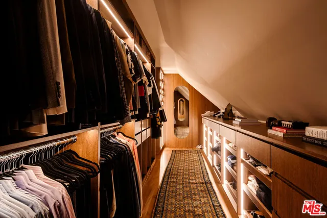 a view of walk in closet with clothes and shoes