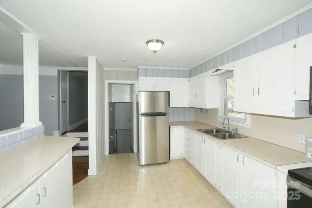 a kitchen with a sink a refrigerator and cabinets