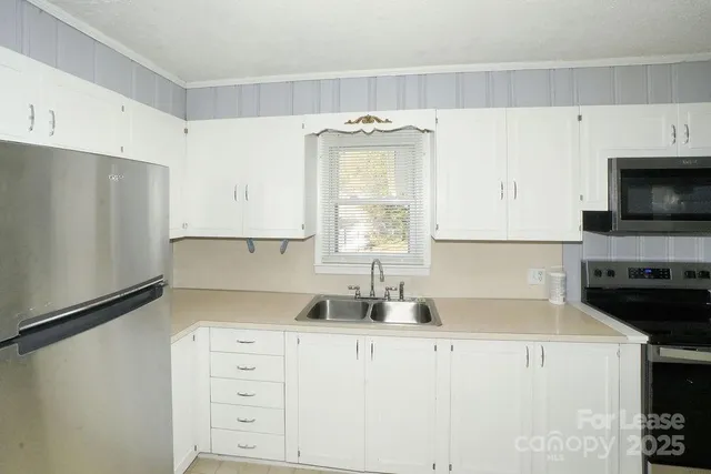 a kitchen with stainless steel appliances a refrigerator sink and cabinets