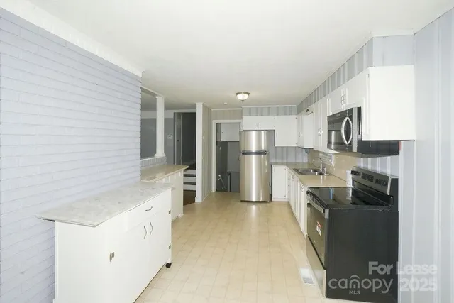 a kitchen with stainless steel appliances granite countertop a refrigerator a stove and a sink
