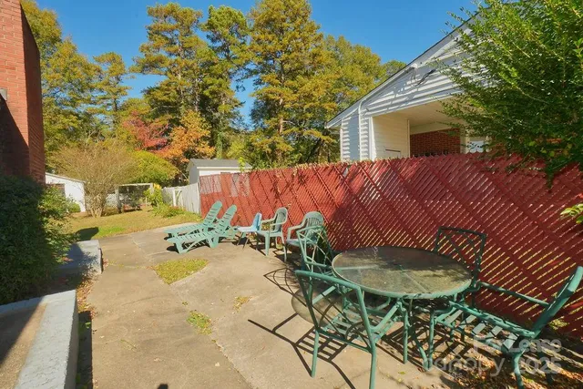 a view of a backyard with table and chairs with wooden fence