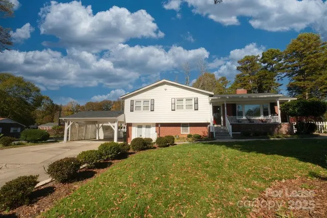 a view of a house with a back yard and a garden
